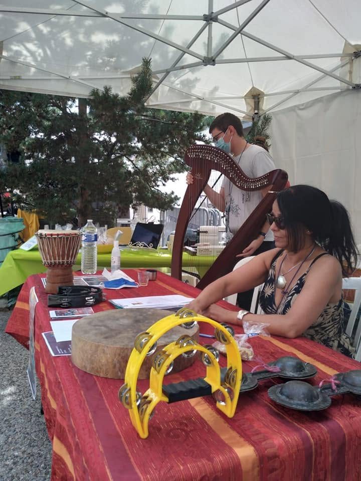 Stand sous tente avec instruments exposés : krakebs, tambourin, djembé, harpe