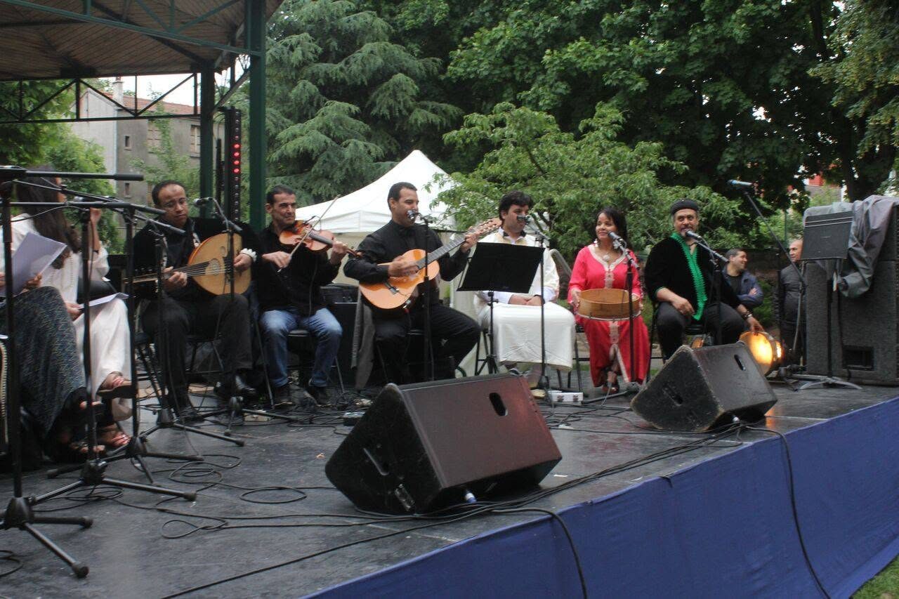 Sept musiciens sur une scène en bois en plein air